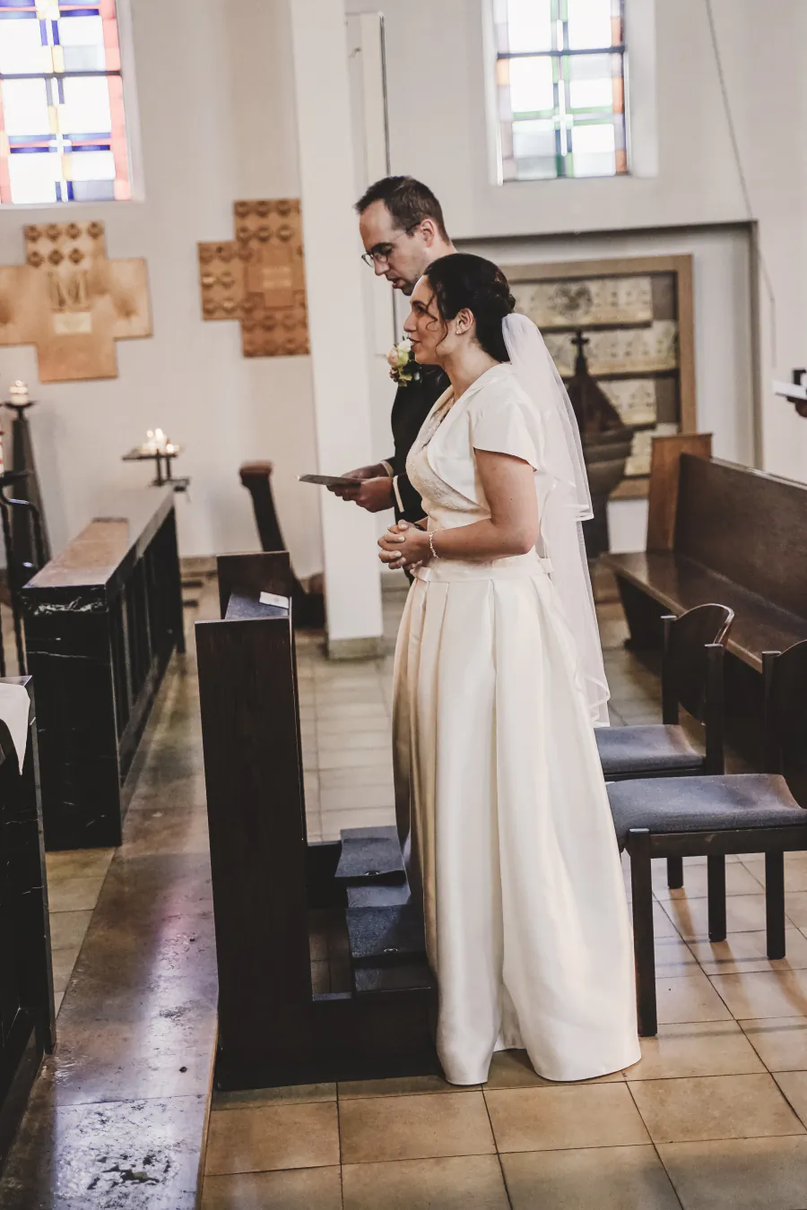 Ein Brautpaar steht während der Trauung vor dem Altar einer Kirche