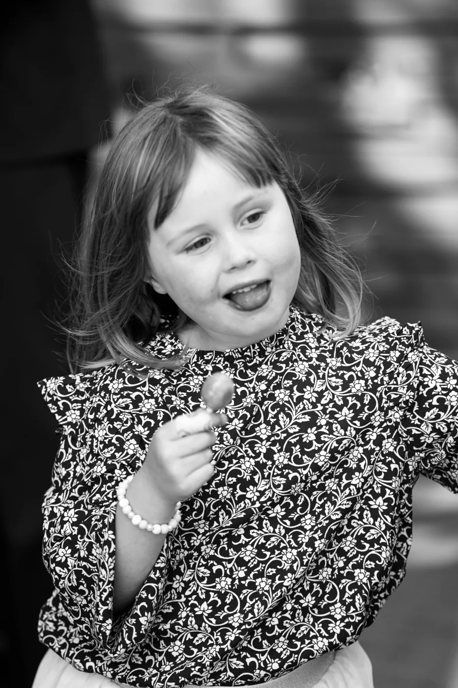 Schwarzweißportrait eines Mädchens mit einer kleinen Blume in der Hand