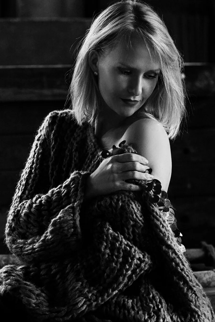Schwarzweißportrait einer Frau im groben Strickpullover