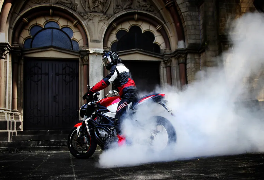 Ein Motorrad zieht eine Rauchwolke vor einem alten Kirchenportal